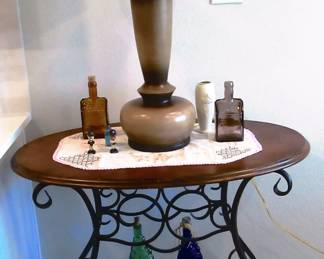 Ornate oval table, lamp and collectors' bottles.