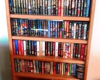 Collection of paperback books and shelf. Sold as collection only. Approx. 250 books numerous authors. If interested, please bring your own boxes for packing.