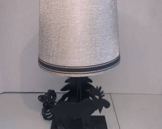 Table top lamp. Approximately 14 inches tall. Has tree and moose cut out
