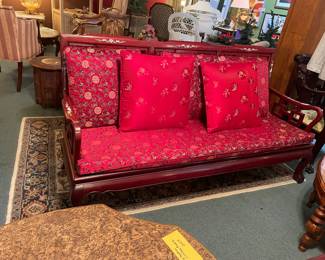 Large rosewood sofa with removable red cushions 
