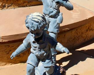 Little boys playing outdoor sculpture garden decor 