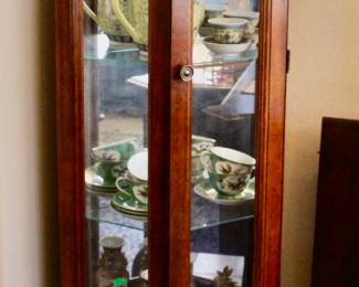 Tall wood display case with glass shelves and storage cabinet at base