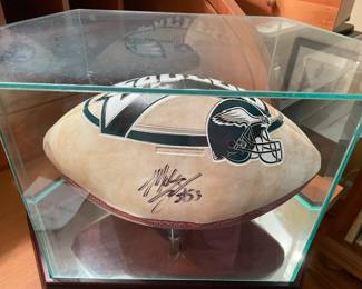 Signed football in glass case.