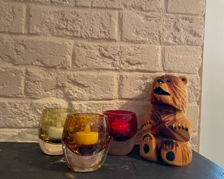 Candles in glass bowls and carved bear.