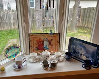 Decorative serving trays, collectible cups and saucers and tin coffee and creamer.