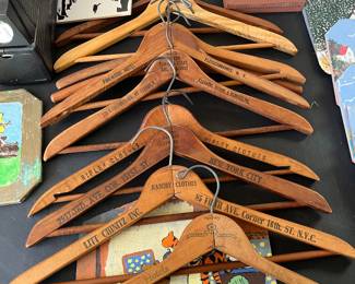 Antique wooden hangers with advertising stamped on each one.