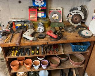 Variety of hand tools, circular saw, electric drills and ceramic planters.