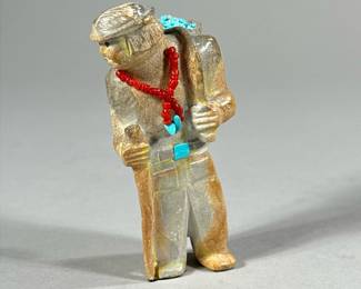 FREDDIE LEEKYA ZUNI FETISH CARVING | Showing figure of a man with beadwork necklace carrying collection of turquoise. Signed “FL” on bottom. Statue height: 3.5in