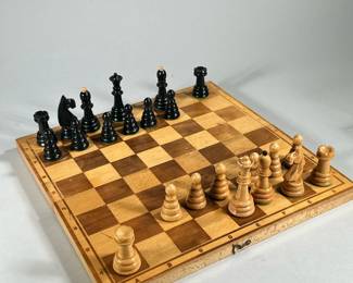 WOOD CARVED FOLDING CHESS BOARD | Folding wooden chessboard with carved wood pieces marked "POLAND' on interior.