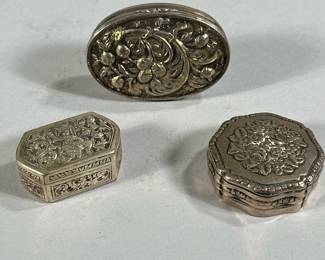 (3PC) SILVER SNUFF BOXES | Includes: oval snuff box with fruit decoration stamped on top (1.4 ozt), Round floral decorated snuff box stamped on bottom "8305" (0.9 ozt), and small oval box with figure stamped on top, "T90" stamped on bottom (0.9 ozt) Total weight: 3.1 ozt