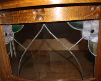 Curved cabinet has stained glass flowers
