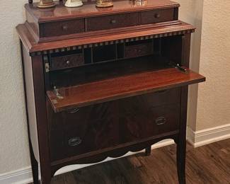 antique desk, writing pad folds up and it is a slender chest 