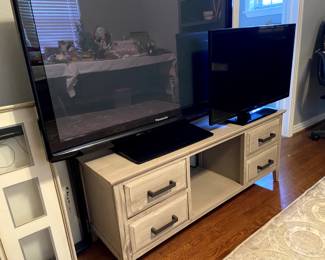 Modern TV stand and a couple of TVs.