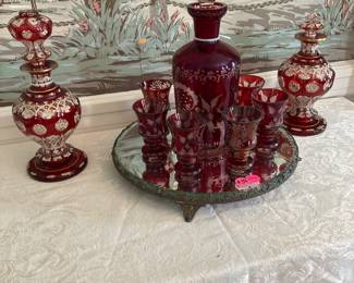 RED CUT TO CLEAR DECANTER SET IN MIDDDLE, ART GLASS WITH STOPPER ON LEFT. SAME ON RIGHT BUT WITHOUT THE STOPPER. PLATEAU BEVELED MIRROR. 