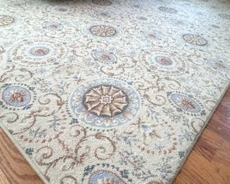 Multi-color edged polyester carpet in cream, with pale blue and light brown medallions, one corner has a cut, could use a steam cleaning, but is in good condition otherwise 8'4" x 11'