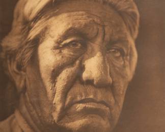 Edward Sheriff Curtis (American, 1868-1952) Photogravure on Paper, Ca. 1927, "Reuben Taylor (Istofhuts) - Cheyenne", H 14.4375" W 11.4375" | Printed by Suffolk Engraving & Electrotyping Co., Cambridge, Mass. from the copyright photograph 1927 by E.S. Curtis. Plate 670 from the North American Indian volume 19 by Edward Curtis. Sheet size: H  21.75", W 17.75". Matted and framed under glass, H 24.5", W 19.5". Provenance: Property of Prominent Collector, Birmingham, Michigan