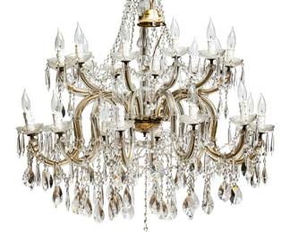 Maria Theresa Style, 24 Light Crystal Chandelier H 41" Dia. 41" | the chandelier offers garlands of octagon and rosette cut crystal pieces with French style cut prisms hanging from the arms. Terminating with a single, central faceted crystal sphere. Each branch extends from center shaft having a single light. Provenance: Property from a Waterford, MI private collector. Purchased from the Michigan Design Center. 