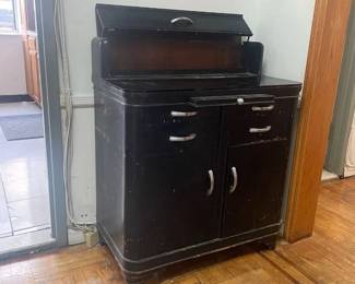 Antique Wooden Doctors Cabinet with metal drawers, and wooden doors and black glass top. Painted black. $500.