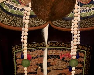 Detail of robe and beaded necklace.