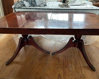 Double pedestal mahogany dining table with 2 leaves and pads