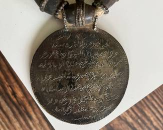 Omani silver pendant on a necklace with large silver beads and two 18th century coins on a thick cord