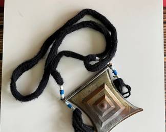 North African brass pendant with geometric designs and a shackled jinn