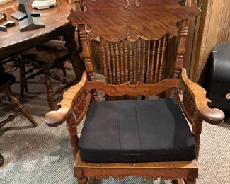 Early 1900's Rocking Chair - Oak featuring spindles, apron front, unique design back and arms.