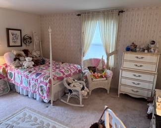 Beautiful little girls bedroom. Four poster white bed, pristine white with gold trim dresser, white wicker adult chair, white wicker children's rocking chair