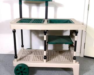 NIAB209 Suncast Rolling Garden Cart Made out of hard plastic, comes with 2 plastic wheels for easy moving. Has utility hooks and a upper shelf.
