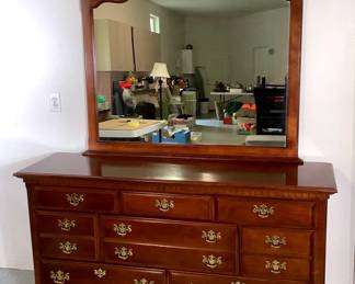 NIAB215 Dresser With Mirror Solid wood dresser with mirror and 8 drawers with brass handles. Top of the dresser has a little bit of scratches and some minor wear.&nbsp;
