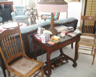 Pair of antique chairs with needlepoint seats, wood table with drawer, fringed Victorian lamp