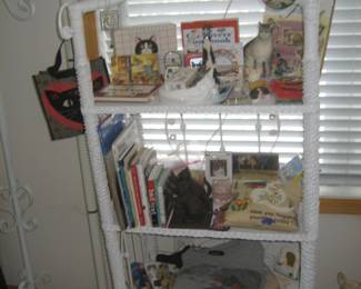 Vintage white wicker étagère and cat books, decor, and collectibles
