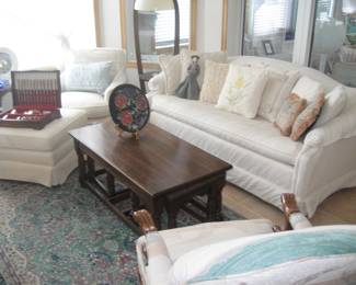 Upholstered sofa, chairs, with an ottoman, wooden coffee table with nested end tables, decorative wooden plate
