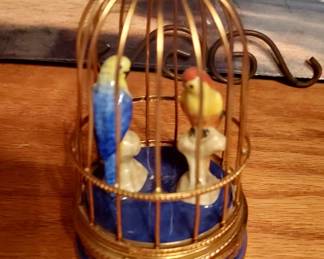 Ceramic parrots in brass birdcage