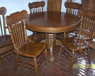 Oak claw foot pedestal table w/ 1 leaf and six chairs