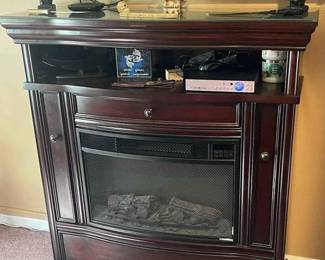 Add a touch of elegance and warmth to your living space with this classic entertainment unit, featuring a built-in electric fireplace. The rich, dark wood finish and sophisticated design make it a stunning focal point for any room. It's not only an aesthetic piece but also functional, with ample space above for a large TV and shelves for your devices and decorative items. The electric fireplace offers a cozy ambiance and heat with the flip of a switch, providing the perfect environment for relaxing evenings at home BEST OFFER