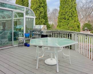 This is the Patio consisting of Kitchenaid Stainless Steel Grill and Glass Table with Chairs.