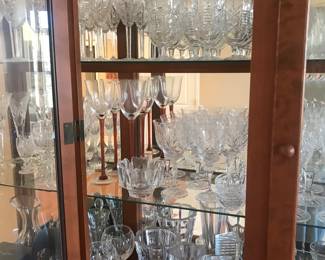 Cabinet has 2 built in lights for viewing and is  filled with crystal pieces from Waterford, Galway, Baccarat and Orrefors!