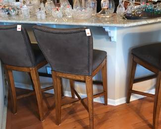 Suede barstools in front of the Waterford displayed on the bar!