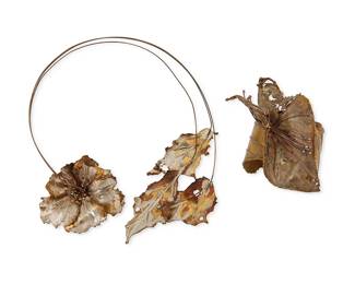 3013
A Set Of Mercura NYC Mixed Metal Botanical Jewelry
Late 20th century
Cuff with label affixed verso: Mercura / 9
Two works in brass and mixed metal comprising a three wire collar necklace with floriform and leaf front terminals, and a corsage-style mixed-metal cuff bracelet with a large sculptural flower to center, 2 pieces
Necklace: 18.5" L; Cuff: 6.25" total inner C x 3.75" H, with a 0.75" gap
Estimate: $300 - $500