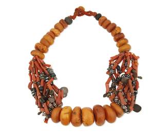 3014
A Large Amber And Glass Bead Necklace
20th century
Appears unmarked
A North African-style heavy, chunky necklace with graduated amber beads alternating with multistrands of branch coral, small shells, glass beads, and stamped silver discs and charm elements, with a corded bead and loop closure
30" L x 2" Dia.
Estimate: $300 - $500