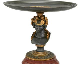 3120
Late 19th Century
A French Figural Bronze Tazza
Signed: TT
The patinated bronze tazza with wide shallow dish centering a portrait roundel of Pan atop a figural pedestal, likely Bacchus, adorned with gilt grapevines raised on a circular foot with foliate and floral motifs set on a rouge marble base
12.625" H x 14.625" Dia.
Estimate: $400 - $600