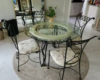Glass top and wrought iron table with 4 chairs 