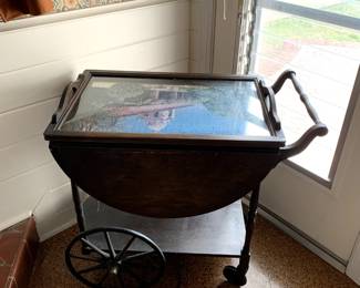 #66	Wood Drop-Side Tea  Cart on  Wheels w/top lift-up Display Tray (fits on top w/folded down sides) -38-18x30x28T  (as is finish w/puzzle under glass)	 $175.00 			
