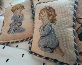 Needlepoint pillows of praying children.