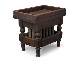 159
Early 19th century
A Carved Wood And Tin Candle Mold
The candle mold with sloped upper tray and twenty-four forms housed in a small wood stand with turned supports
14" H x 15" W x 10" D
Estimate: $500 - $700