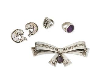 225
A Group Of William Spratling Silver And Amethyst Jewelry
William Spratling (1900-1967)
Circa 1933-1939, 1940-1946,1951-1956; First and Third Design Periods; Taxco, Mexico
Each stamped for William Spratling; further variously stamped: Made in Mexico / Silver / Taxco / 980 / 925 / Eagle 30
Five works comprising an amethyst-set bow brooch (2" H x 4.5" H), a silver ring with amethyst cabochon (Ring size: 5.75), a rectangular "crowned pyramid" silver ring with rolled fringe edges (Ring size: 5), and two silver and abalone fish pins, oriented face-to-face (1.375" H and 1" H), 5 pieces
77.9 grams gross
Estimate: $600 - $800
