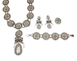 307
A Set Of Silver Filigree And Seed Pearl Jewelry
Mid-20th century
Appears unmarked
Four works comprising an elaborate silver filigree and seed pearl medallion link necklace with a bow motif pendant (26" L x 5" H), together with a matching link bracelet (9.375" L x 1.625" H), a medallion ring (Ring size: 7.75; 1.375" Dia.) and a pair of clip dangle earrings with bows (Each: 3" H x 1.375" W), 5 pieces
263.0 grams gross
Estimate: $600 - $900