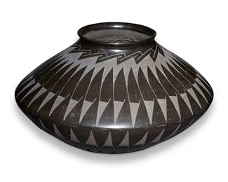 132
Tavo Silveira (20th Century; Mata Ortiz, Mexico)
A broad-shouldered blackware pot, mid-20th century
Signed on the underside: Tavo Silveira
The black on black pot with near-mirrored radiating feather motifs to shoulder and body
7.5" H x 12.75" Dia.
Estimate: $200 - $400