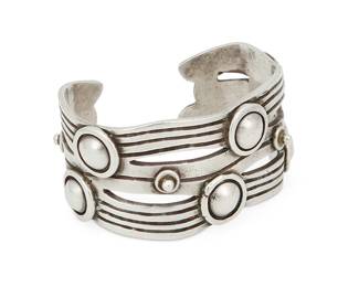 242
A William Spratling "River Of Life" Silver Cuff Bracelet
William Spratling (1900-1967)
Circa 1944-1946, First Design Period; Taxco, Mexico
Stamped for William Spratling; further stamped: Made in Mexico / Silver
Designed as incised silver waves with applied narrow Aztec rings
6.5" total inner C x 1.375" H, with a 1" gap
102.6 grams
Estimate: $800 - $1,200